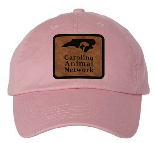 Pink dad hat featuring the Carolina Animal Network logo in a brown and black leatherette patch. Front view.