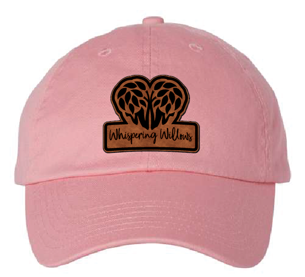 Pink dad hat with the Whispering Willows logo in brown and black