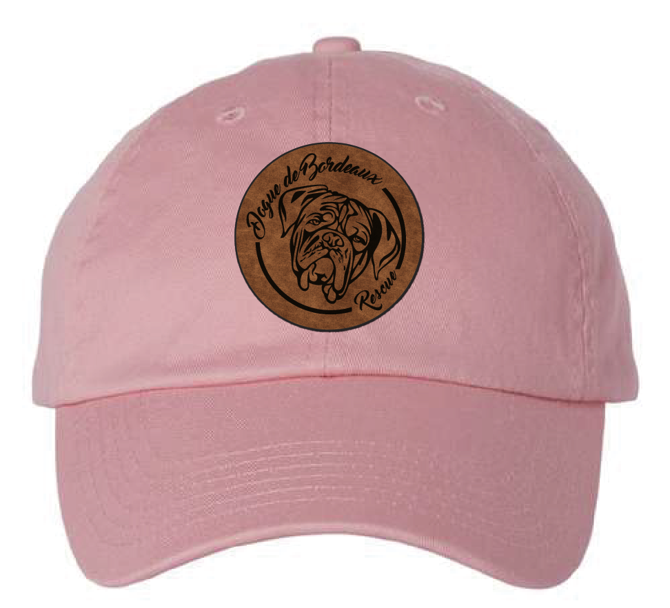 Pink dad hat featuring the Dogue de Bordeaux Rescue logo in a brown and black leatherette patch. Front view.