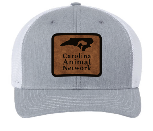 Heather gray/white trucker hat featuring the Carolina Animal Network logo in a brown and black leatherette patch. Front view.