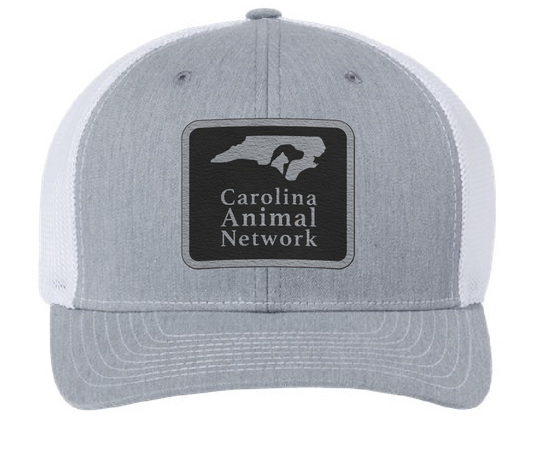 Heather gray/white trucker hat featuring the Carolina Animal Network logo in a black and silver leatherette patch. Front view.