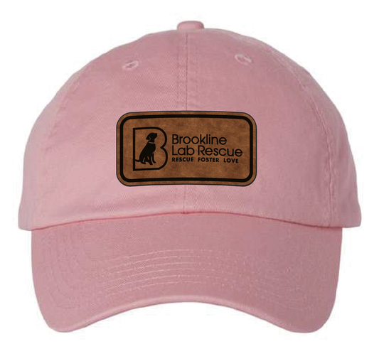 Pink dad hat featuring the Brookline Lab Rescue logo in a brown and black leatherette patch. Front view.