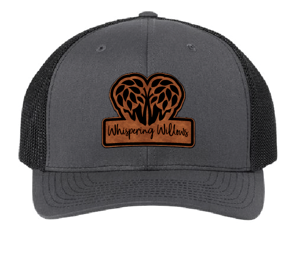 Charcoal and black trucker hat with the Whispering Willows logo in brown and black