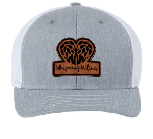 Gray and White trucker hats with the Whispering Willows logo in brown and black